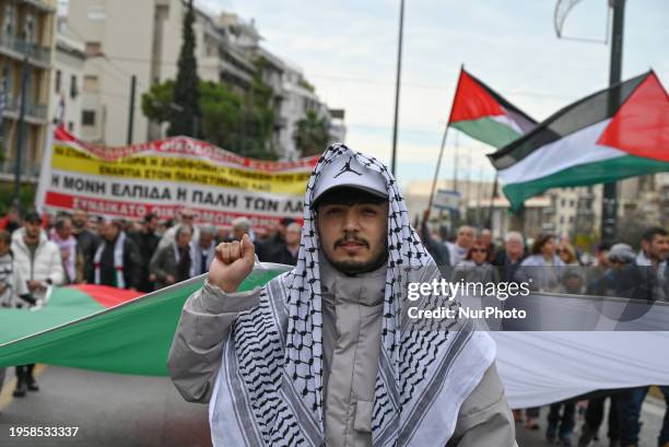 Protesters are marching, holding banners and Palestinian flags, during a pro-Palestinian protest against the ongoing war in Gaza in Athens, Greece,...