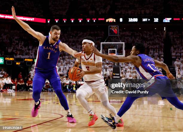 Tamin Lipsey of the Iowa State Cyclones moves the ball under pressure from Hunter Dickinson and Elmarko Jackson of the Kansas Jayhawks in the first...