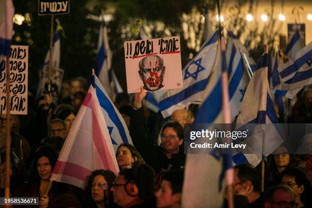 Protesters hold signs and flags during a demonstration against Israeli Prime Minister Benjamin Netanyahu and the Israeli government on January 27,...