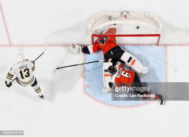 Charlie Coyle of the Boston Bruins scores a third period goal against goaltender Cal Petersen of the Philadelphia Flyers and Travis Sanheim at the...