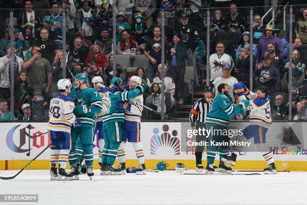 Luke Kunin of the San Jose Sharks fights against Jeff Skinner of the Buffalo Sabres in the third period at SAP Center on December 27, 2024 in San...