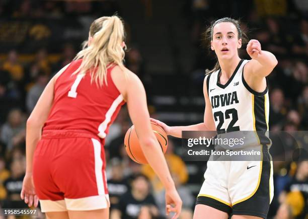 Iowa guard Caitlin Clark gestures as she brings the ball up the court and Nebraska guard Jay Shelley defends during a women's college basketball game...