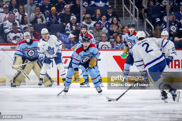 Mason Appleton of the Winnipeg Jets defends as he keeps an eye on Simon Benoit of the Toronto Maple Leafs as he plays the puck at the point during...