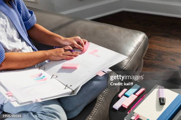 young asian woman studying on sofa, using page marker - color coded stock pictures, royalty-free photos & images