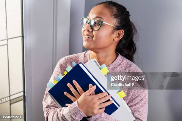 asian woman holding textbooks coded with page markers - color coded stock pictures, royalty-free photos & images