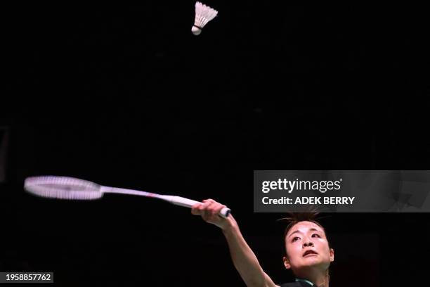 Nozomi Okuhara of Japan hits a return against Wang Zhiyi of China during their women's singles final match at the Indonesia Masters badminton...