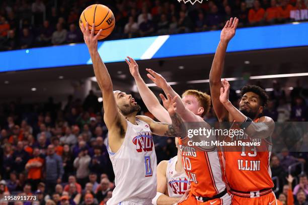 Boo Buie of the Northwestern Wildcats shoots over Luke Goode and Quincy Guerrier of the Illinois Fighting Illini during the first half at Welsh-Ryan...