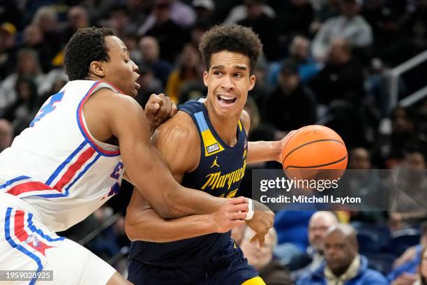 Oso Ighodaro of the Marquette Golden Eagles dribbles by Churchill Abass of the DePaul Blue Demons in the first half during a college basketball game...