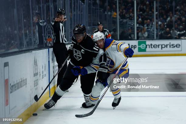 Anze Kopitar of the Los Angeles Kings skates the puck against Henri Jokiharju of the Buffalo Sabres in the second period at Crypto.com Arena on...