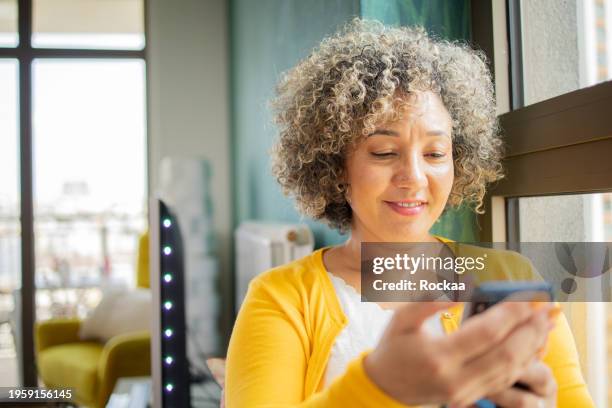 happy mature woman using phone - dating app stock pictures, royalty-free photos & images