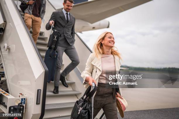diverse passengers using air stairs to exit an airplane - business travel stock pictures, royalty-free photos & images