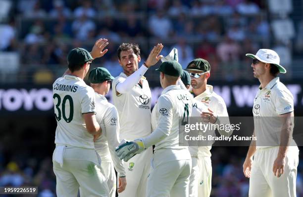 Mitchell Starc of Australia celebrates with team mates after taking the wicket of Justin Greaves of the West Indies during day one of the Second Test...