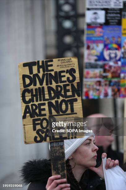 Protester holds a placard saying 'The Divine's Children Are Not For Sale' outside the gates of Buckingham Palace, during the demonstration. A group...