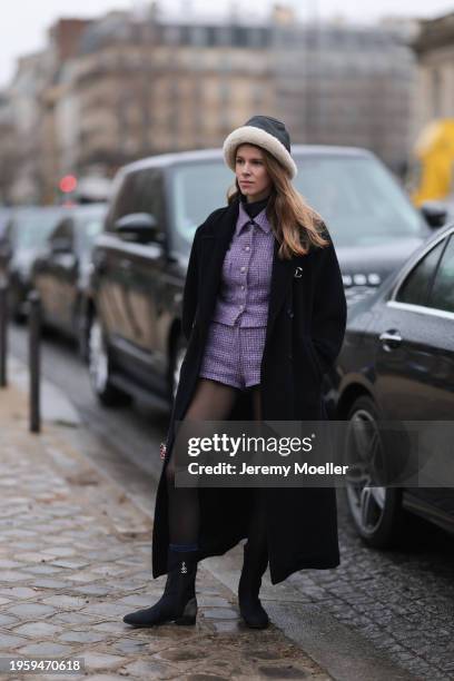 Monica de La Villardiere is seen wearing a purple tweed jacket, a purple tweed short, black tights, dark blue boots with Chanel logo, a long black...