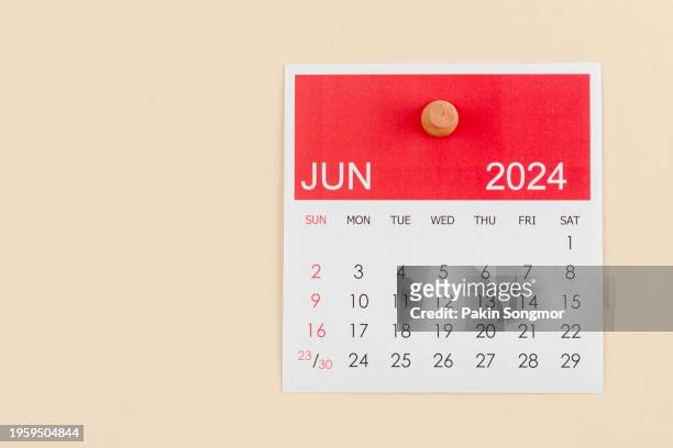 desk calendar 2024: june calendar is used to plan daily work and life with a push pin on a beige color paper background. - calendar june stock pictures, royalty-free photos & images