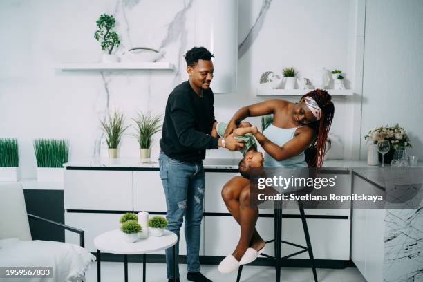 african black family enjoying playing with baby son at home - human arm photos et images de collection