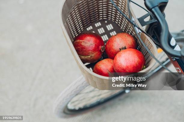 pomegranates in basket on bicycle. - fahrradkorb stock-fotos und bilder