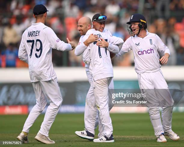 Jack Leach of England celebrates with Tom Hartley, Joe Root and Ollie Pope after dismissing India captain Rohit Sharma during day one of the 1st Test...