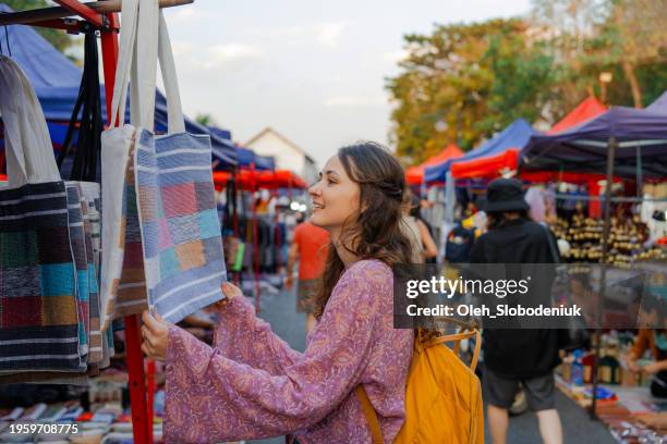woman exploring street market in luang prabang - marktkraam stockfoto's en -beelden