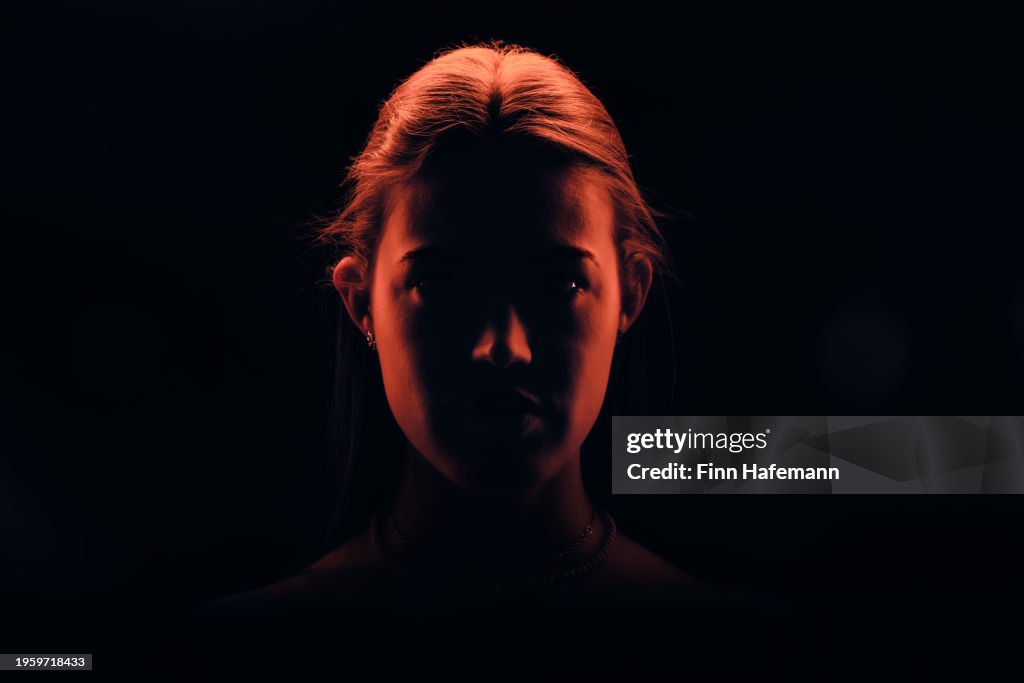 Young Good Looking Woman With Her Hair Tied Up Watching Right Into The Camera Illuminated In Red Light