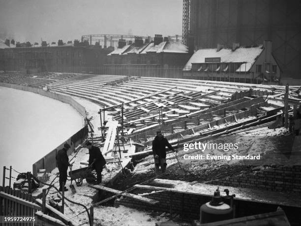 Three men at work during the refurbishment of international cricket ground The Oval in Kennington, London, UK, 24th February 1955.