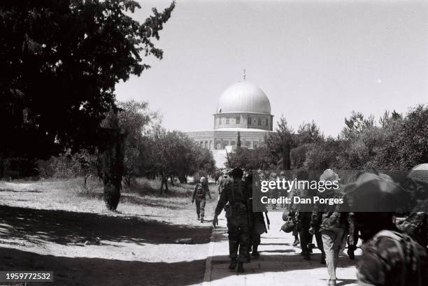 View of reserve soldiers from the Israeli Defense Forces' 55th Paratroopers Brigade walk along a path towards the Dome of the Rock on the Temple...