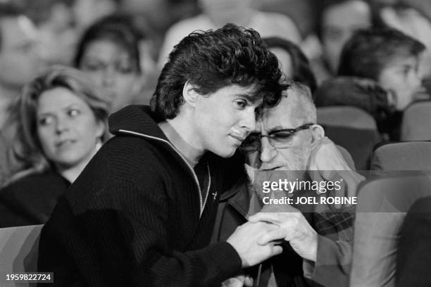 Le chanteur Jean-Luc Lahaye réconforte l'Abbé Pierre très ému le 16 d�écembre 1986 lors de l'émission diffusée sur Antenne 2 "Donne moi la main" en...