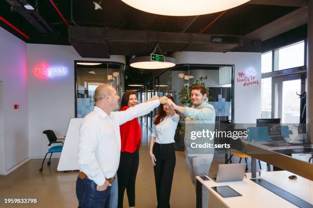 a team of colleagues joining their hands together in unity in a creative luxury office - turkey coup photos et images de collection