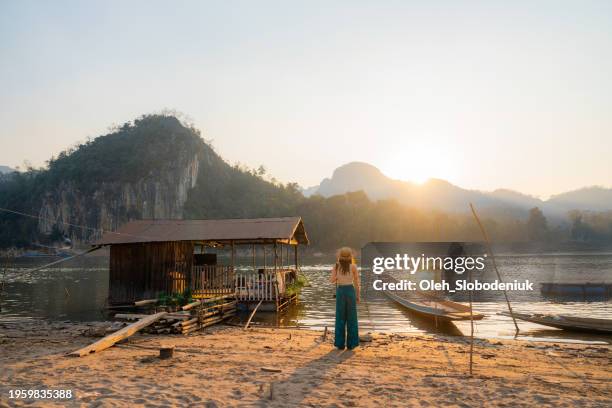 woman with camera looking at sunset over mekong river - mekong delta stock pictures, royalty-free photos & images