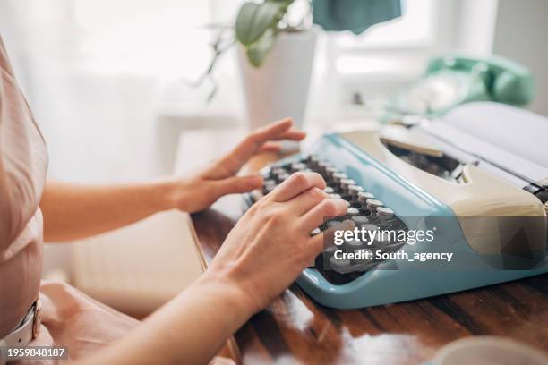 woman using typewriter - schreibmaschine stock-fotos und bilder