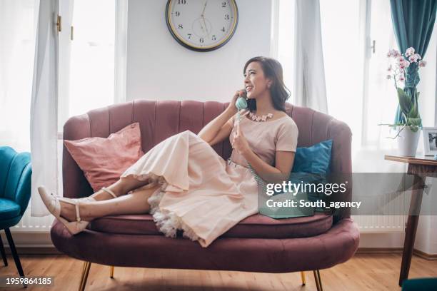 mujer hablando por teléfono con cable - teléfono con cable fotografías e imágenes de stock