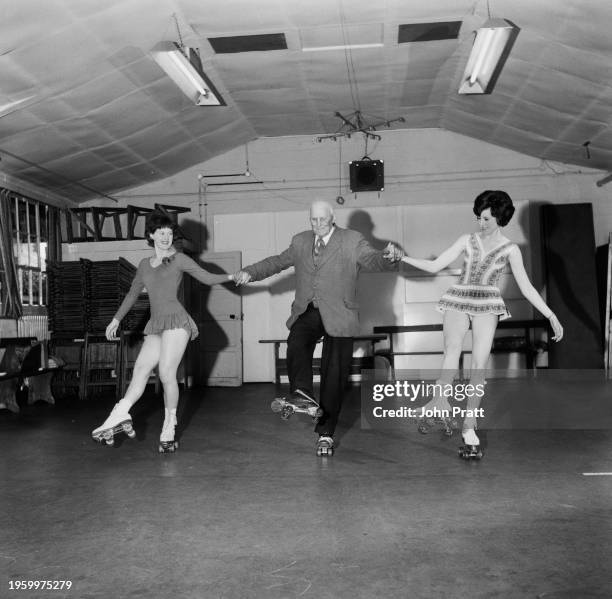 Harry Bull, aged 80, roller-skating with Janet Quince , aged 18, and Patricia Gamble, aged 19, in the village of Chainbridge, near March in...