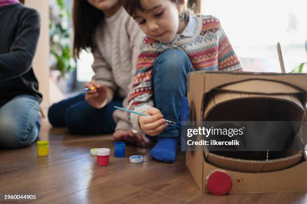 children doing home activity at home, they are painting their spacet helmets made of cardboard. - rpg maker stock pictures, royalty-free photos & images