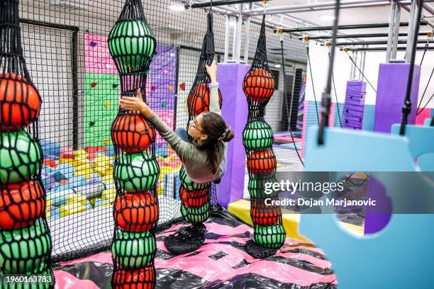 kids having fun at indoor playground hanging on rope - mission court grip stock pictures, royalty-free photos & images