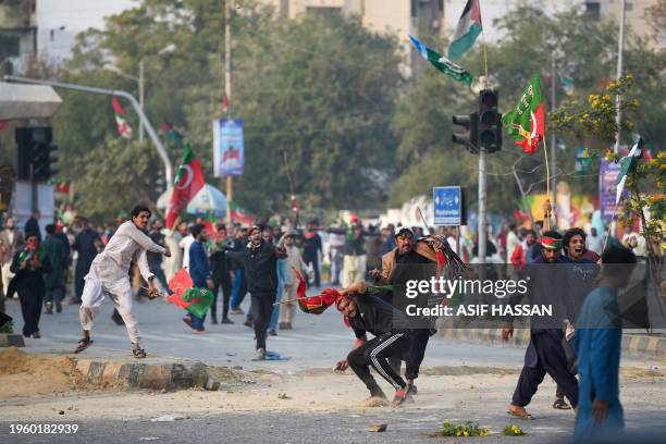 Pakistan Tehreek-e-Insaf party protesters who demand the release of Pakistan's jailed former prime minister Imran Khan, throw stones at the police in...