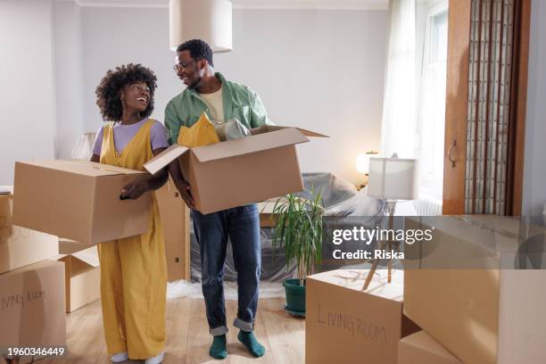 jeune couple qui trouve le bonheur dans les petits moments de l’emménagement dans une nouvelle maison - déballer ses cartons photos et images de collection