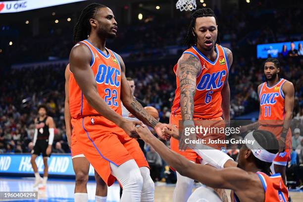 Cason Wallace and Jaylin Williams help Shai Gilgeous-Alexander of the Oklahoma City Thunder off the floor during the first half against the Portland...