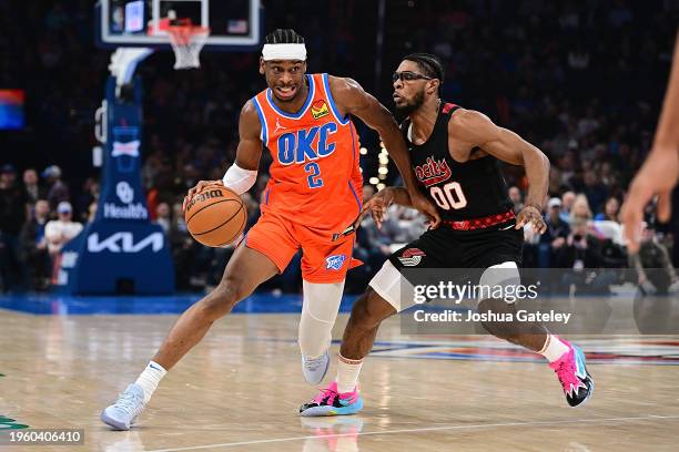 Shai Gilgeous-Alexander of the Oklahoma City Thunder handles the ball during the first half against Scoot Henderson of the Portland Trail Blazers at...