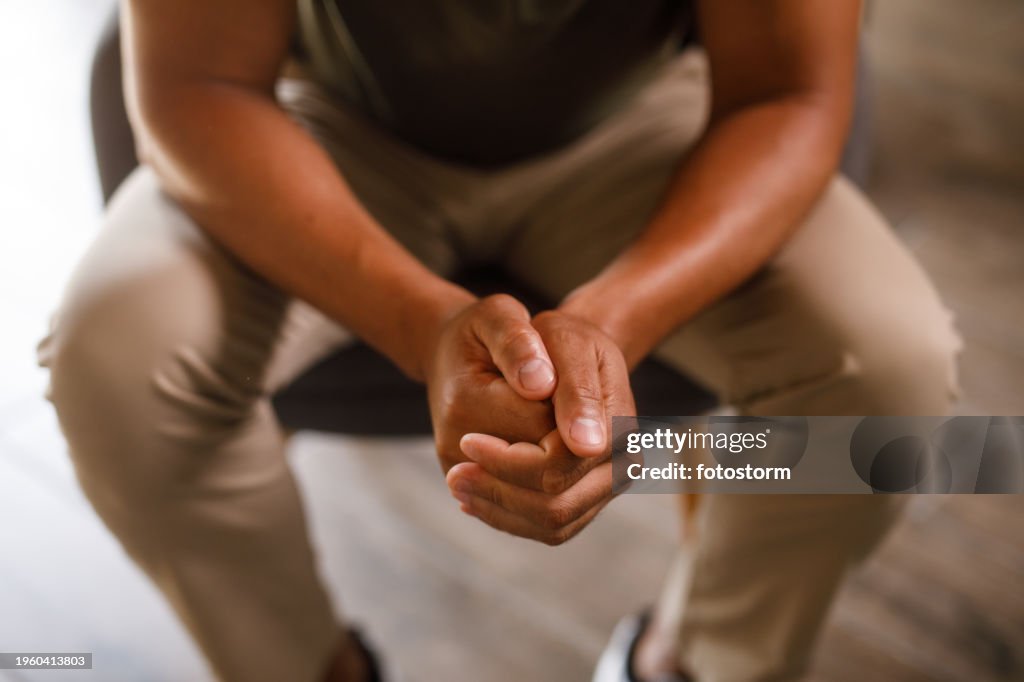 Man cracking his knuckles when feeling anxious