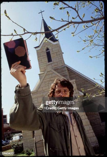 American actor Tim Daly holds up a Bible as he stands in front of a church on the set of the TV movie 'In the line of fire: Ambush in Waco' Tulsa,...