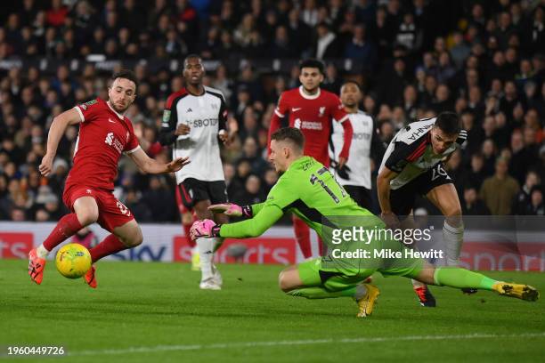 Bernd Leno of Fulham dives at the feet of Diogo Jota of Liverpool during the Carabao Cup Semi Final Second Leg match between Fulham and Liverpool at...