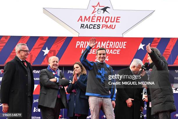 French jockey Clement Duvaldestin , driver of Idao de Tillard, waves on the podium after winning the Grand Prix d'Amerique harness racing horse race...