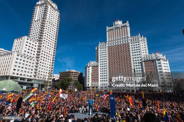 People wave Spanish flags as the Leader of the Opposition Alberto Nuñez Feijoo speaks during a rally against the Socialist government of Pedro...