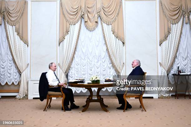 In this pool photograph distributed by Russian state agency Sputnik, Russia's President Vladimir Putin attends a meeting with Belarus' President...