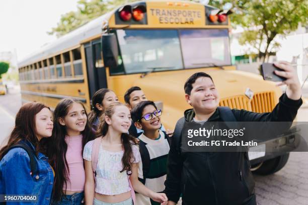 child student friends taking a selfie on mobile phone outdoors - alpha males stock pictures, royalty-free photos & images