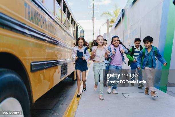 child students running outside the school - skolbarn bildbanksfoton och bilder