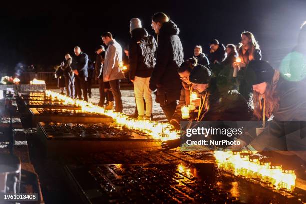 Participants lay candles by the Auschwitz Memorial at the former Nazi German Auschwitz-Birkenau concentration camp during the 79th Anniversary Of...