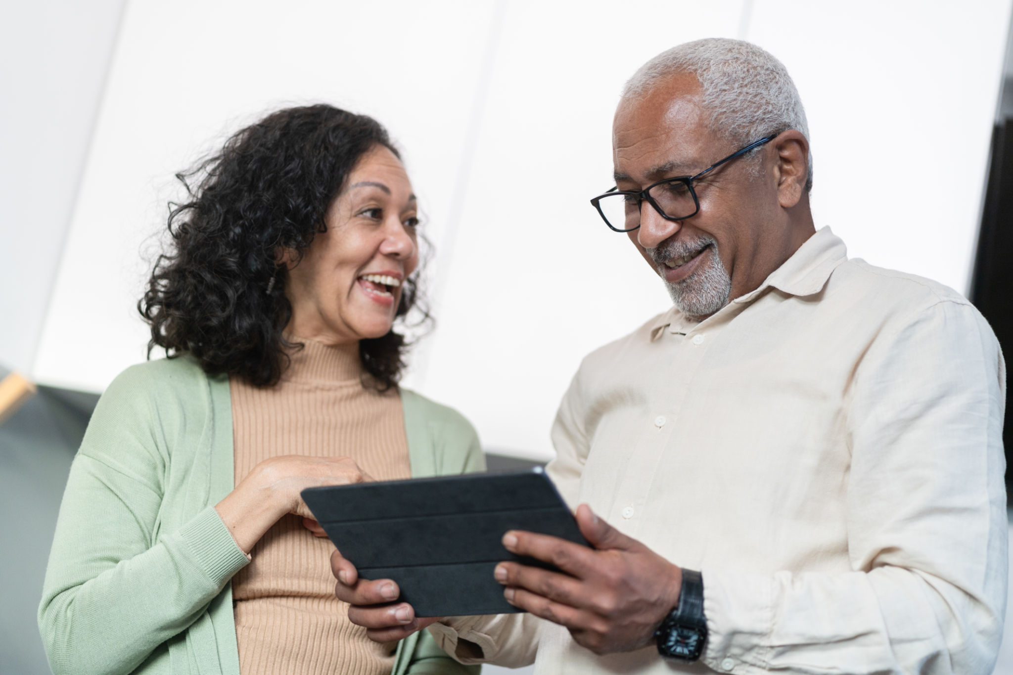 Senior couple using and looking ata tablet computer Senior couple using and looking ata tablet computer
