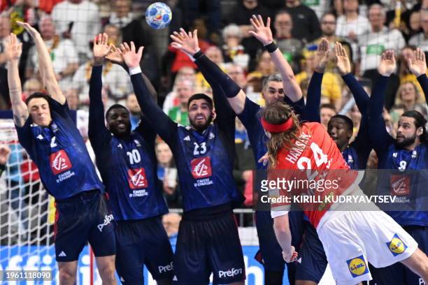 Denmark's left back Mikkel Hansen shoots the ball past France's players during the Men's EURO 2024 EHF Handball European Championship final match...