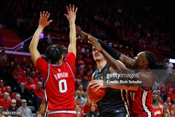 Zach Edey of the Purdue Boilermakers looks to shot as Derek Simpson and Clifford Omoruyi of the Rutgers Scarlet Knights defend during the first half...